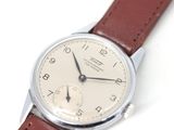 une montre en argent avec un bracelet en cuir marron sur un fond blanc
