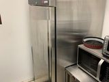 un réfrigérateur et un micro-ondes en acier inoxydable dans une petite cuisine