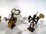 trois figurines posées sur une surface blanche