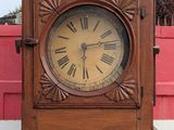 a wooden grandfather clock with roman numerals on the face