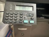 a black printer sitting on top of a desk next to a stack of books