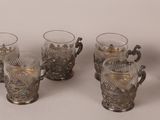 four glasses with handles and handles are lined up on a table
