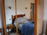 un lit et une chaise dans une chambre équipée d'un grand miroir