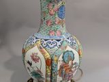 un vase posé sur un socle sur lequel se trouve une lampe