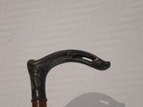 a close up of a walking stick with a shadow on the wall