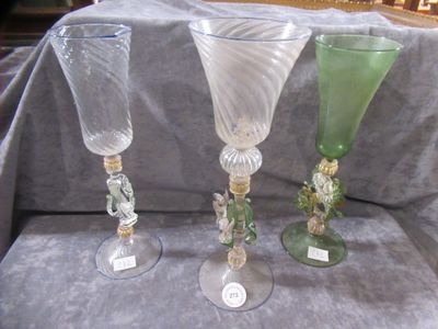 three wine glasses sitting on a table with a gray cloth