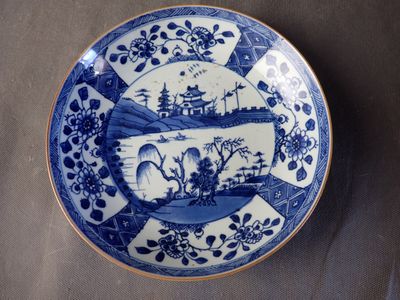 une assiette bleue et blanche représentant un bateau