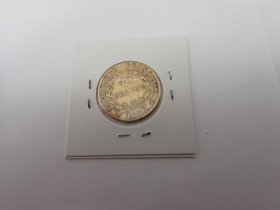 gros plan d'une pièce d'or sur une surface blanche