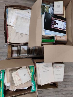 une boîte remplie de livres et de papiers posée par terre