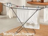 a drying rack with clothes hanging on it in a room