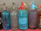 Des bouteilles de différentes couleurs et tailles sont alignées sur une table