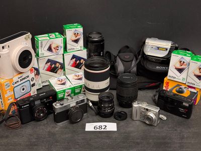 de nombreux appareils photo, dont certains sont posés sur une table