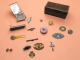 une boîte à bijoux posée sur un fond rose, avec un miroir