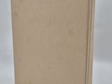a book with a brown cover sitting on top of a white surface