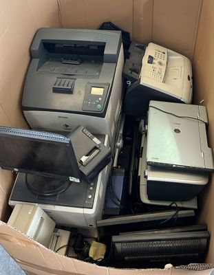 un carton rempli de matériel électronique et d'un ordinateur portable