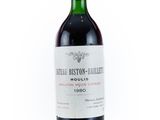 the bottle of red wine is sitting on a white surface