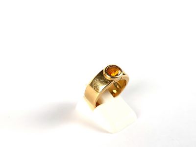 un gros plan d'une bague en or sertie d'une citrine