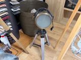 a lamp that is on a tripod next to a fire place