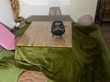 a green blanket on the floor next to a wooden table