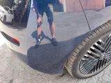 a reflection of a man on the side of a car