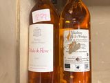 deux bouteilles de vin posées sur une étagère l'une à côté de l'autre