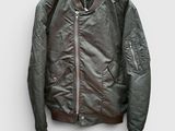 La veste bomber est suspendue à un cintre accroché au mur.