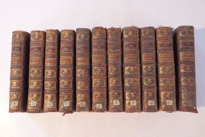 plusieurs vieux livres sont empilés sur une surface blanche