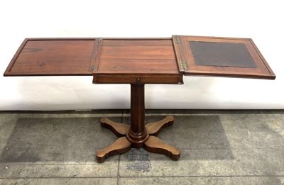 a wooden table with a glass top sitting on a tile floor