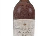 an old bottle of wine sitting on top of a white surface