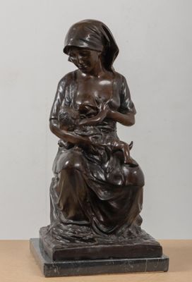 statue of a woman holding a cat on a table