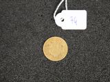 a gold coin and a white tag on a black surface