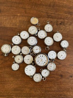 de nombreuses horloges posées sur une table en bois