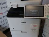 une imprimante blanche posée sur une pile de cartons