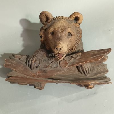 carvings of a bear on a piece of wood on a table