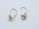 a pair of gold earrings with pearls on them