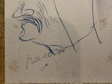 drawing of a man ' s face in a gold frame on a white wall