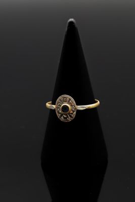 l'image d'une bague en or sur laquelle se trouve une pièce de monnaie