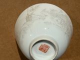 a white vase with a design on it on a brown surface