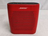 a close up of a red bose bluetooth speaker on a table
