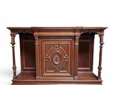a wooden desk with a carved top and two shelves