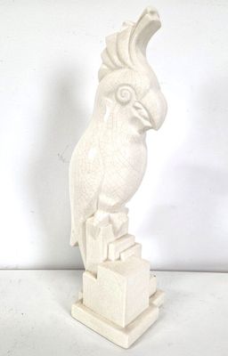 a white sculpture of a bird sitting on top of a box