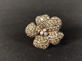 a close up of a gold flower broochle on a black surface