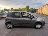 a small grey car parked on the side of the road
