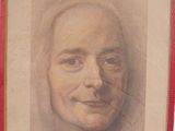 painting of a woman ' s face in a red frame on a wall