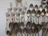 a lot of silver spoons and forks on the wall