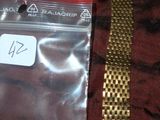 un bracelet en or muni d'une plaque, posé sur une table