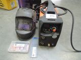 a welder that is sitting on the floor next to some other items