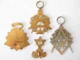 four different metal ornaments are displayed on a white surface