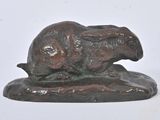 sculpture en bronze représentant un lapin posé sur un rocher, sur fond blanc