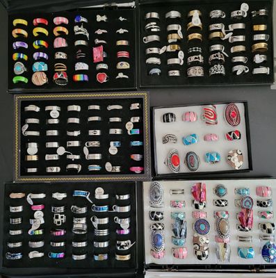 many different types of rings and bracelets displayed in a display case